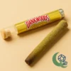 buy-dankwoods-online-banana-kush-main Buy Dankwoods online – Banana Kush strain in gold-labeled tube with a kief-coated pre-roll on soft beige background. Available at MoonrockOnlineShop.