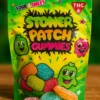 Close-up of Stoner Patch Gummies pack with colorful THC edibles on a wooden surface, branded with the Moonrock Online Shop logo.