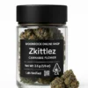 Zkittlez — fruity indica hybrid. Lab-verified 23–25% THC. Fresh-sealed, CA-compliant, discreet California delivery. Zkittlez cannabis flower in a clear jar with matte black lid, front label showing Net Wt 3.5 g and CA THC symbol, with two frosty buds displayed on pure white — Moonrock Online Shop.