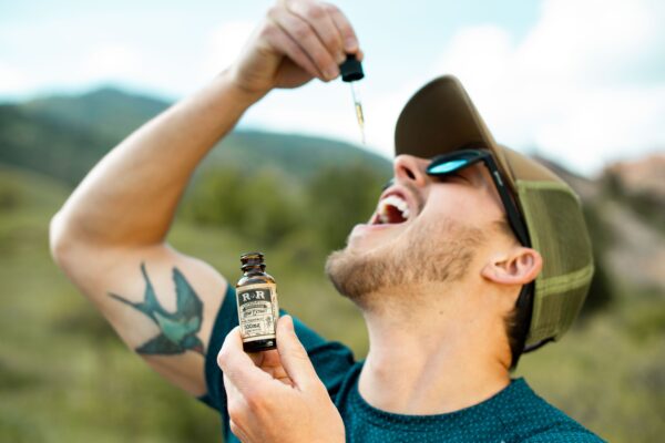 CBD and Cannabis Education. Man meditating with CBD oil bottle nearby, showcasing natural stress relief.