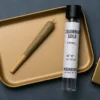 Colombian Gold Preroll 1g – Moonrock Online Shop Lifestyle Photo Premium Moonrock Colombian Gold cannabis 1g jar beside dense golden-green bud, matte-black label with gold accents and Moonrock Online Shop logo.