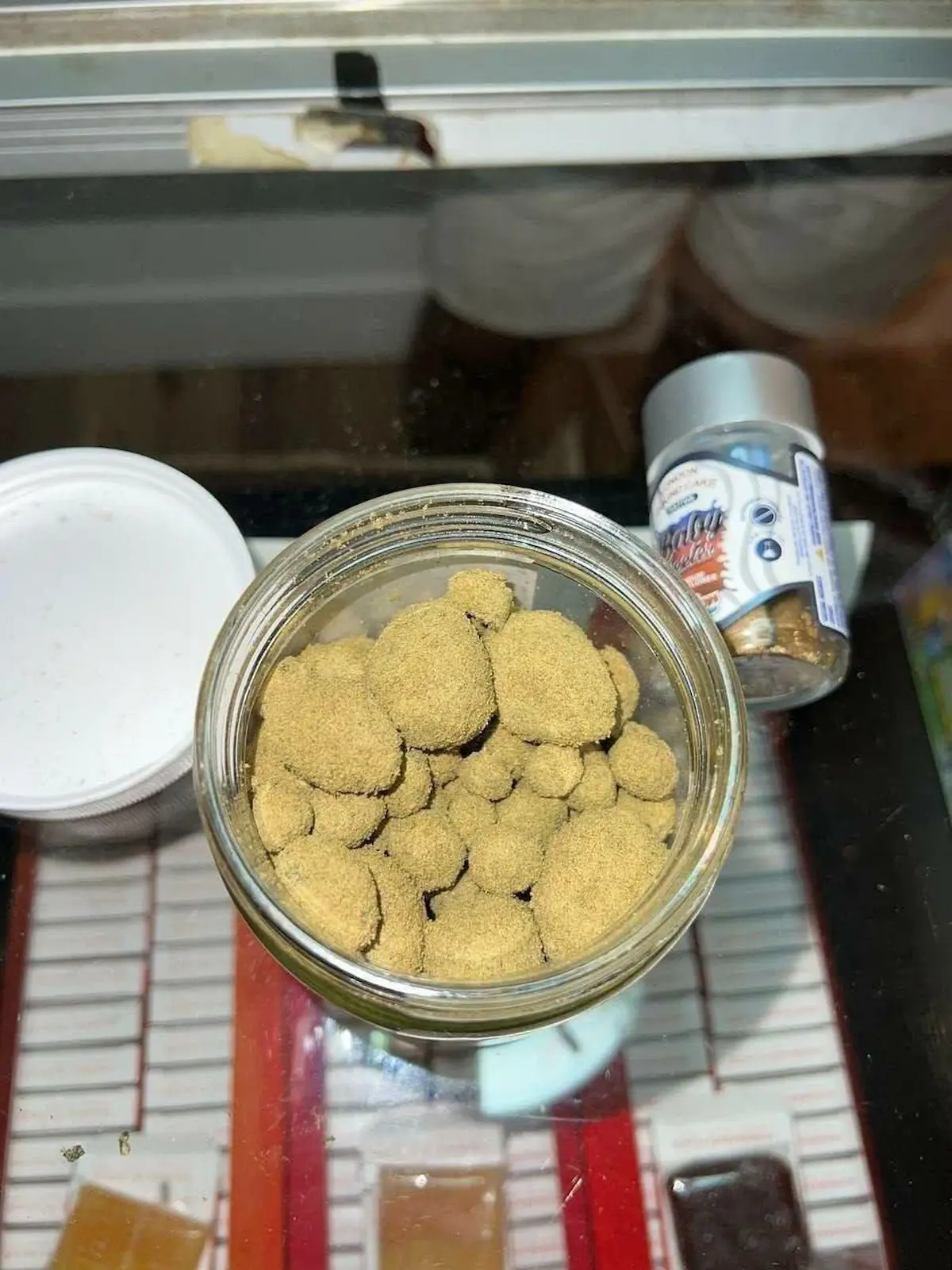 Premium Sun Rocks infused flower with golden amber oil coating and crystalline kief texture