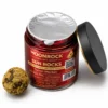 Opened infused flower jar with freshness seal Opened infused cannabis flower jar with foil seal and coated nug on white background
